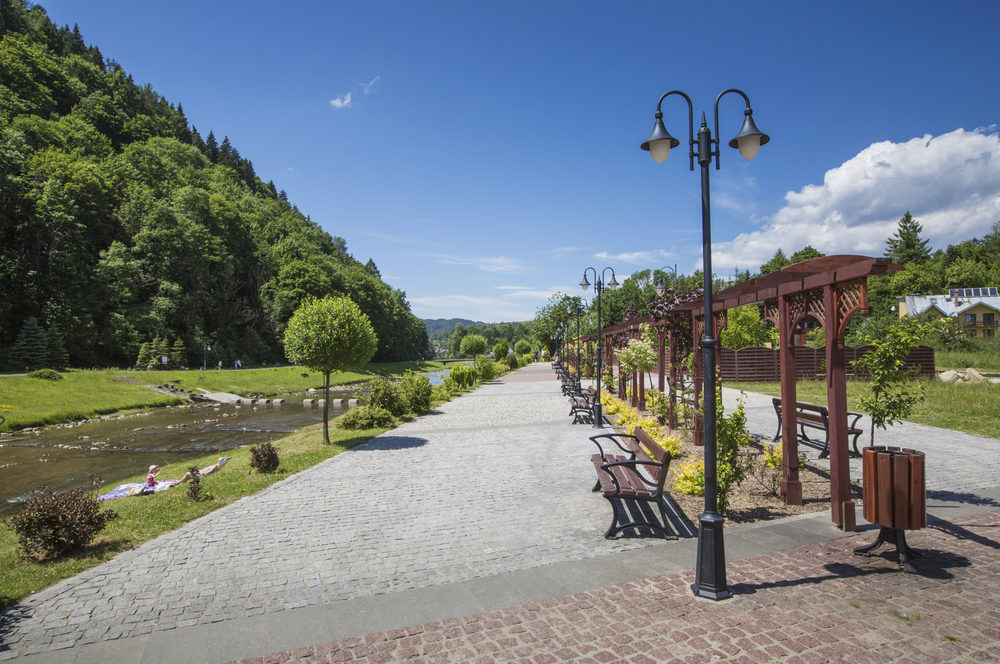 Promenade along a river Szczawnica village on sunny summer day, Beskid Niski Mountains, Poland